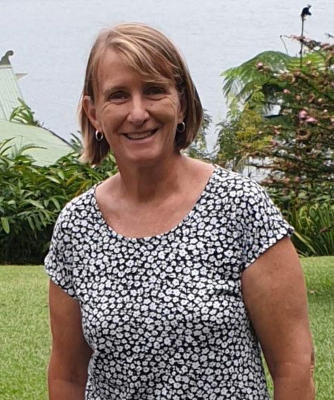 Linda standing and smiling at the camera.