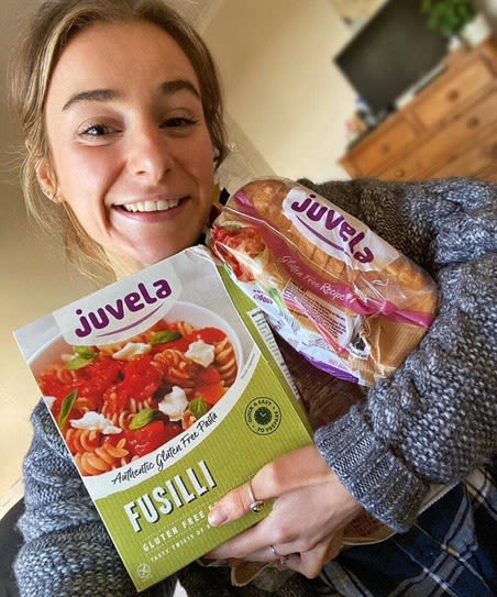 Laura Harry holding some gluten free bread and pasta.
