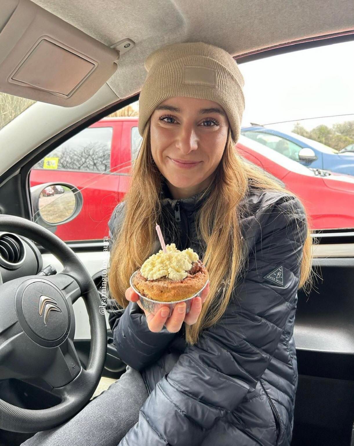 Laura Harry sat in a car, holding a bakery treat.
